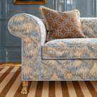 Blue and gold marbled-pattern rolled-arm sofa with a caramel geometric accent pillow